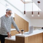 man working on his laptop in his kitchen