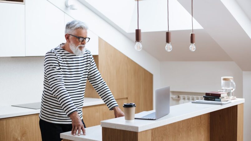 man working on his laptop in his kitchen